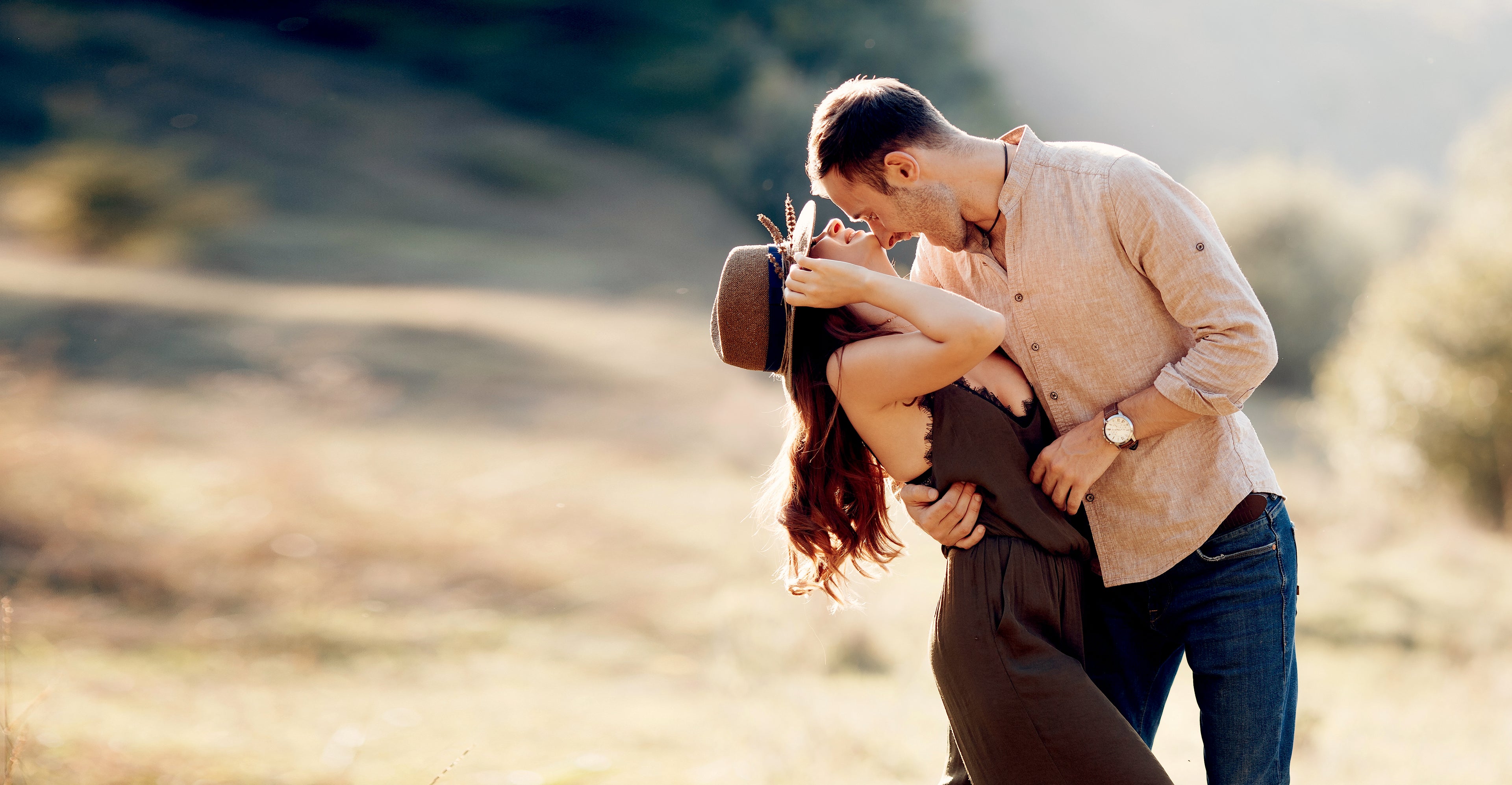 Man and women hugging in a farm looking field.